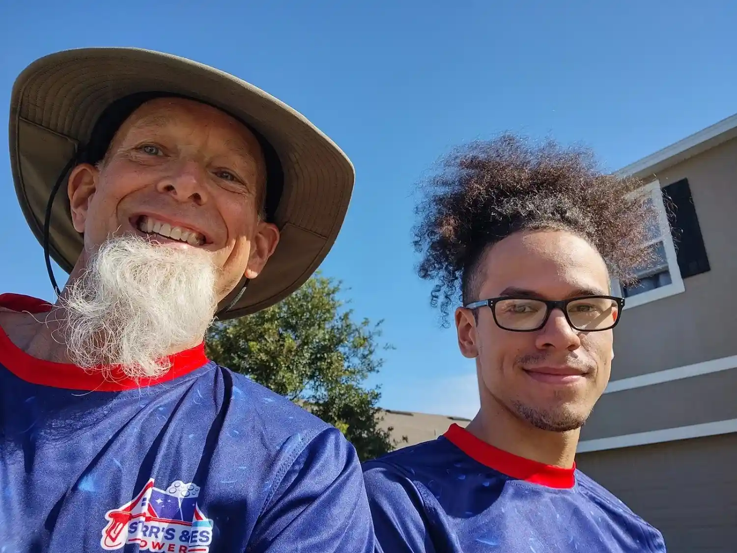 Randy and Matthew from Starr's & Stripes PowerWash in Ocala, wearing matching company jerseys outdoors on a sunny day.